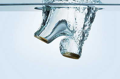 Euro coins falling in water, isolated on white