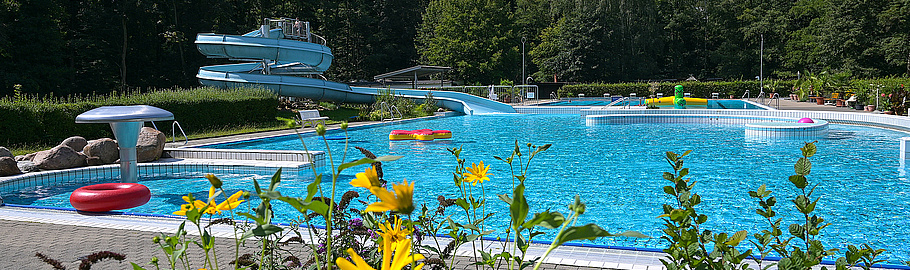 Waldbad Colditz mit großem Schwimmbecken und Wasserrutsche.
