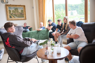 Gemütliche Runde mit den Azubis aus dem 2. und 3. Ausbildngsjahr. Sitzend auf der Couch und in Sesseln. Das Bild erweckt den Eindruck einer lockeren Gesprächsrunde.
