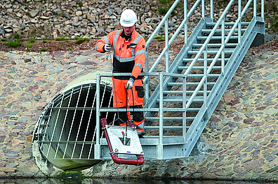 Ein Mitarbeiter von Veolia auf der Treppe des Regenrückhaltebeckens.